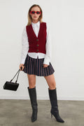 Burgundy V-neck button-front knitted vest layered over a white shirt